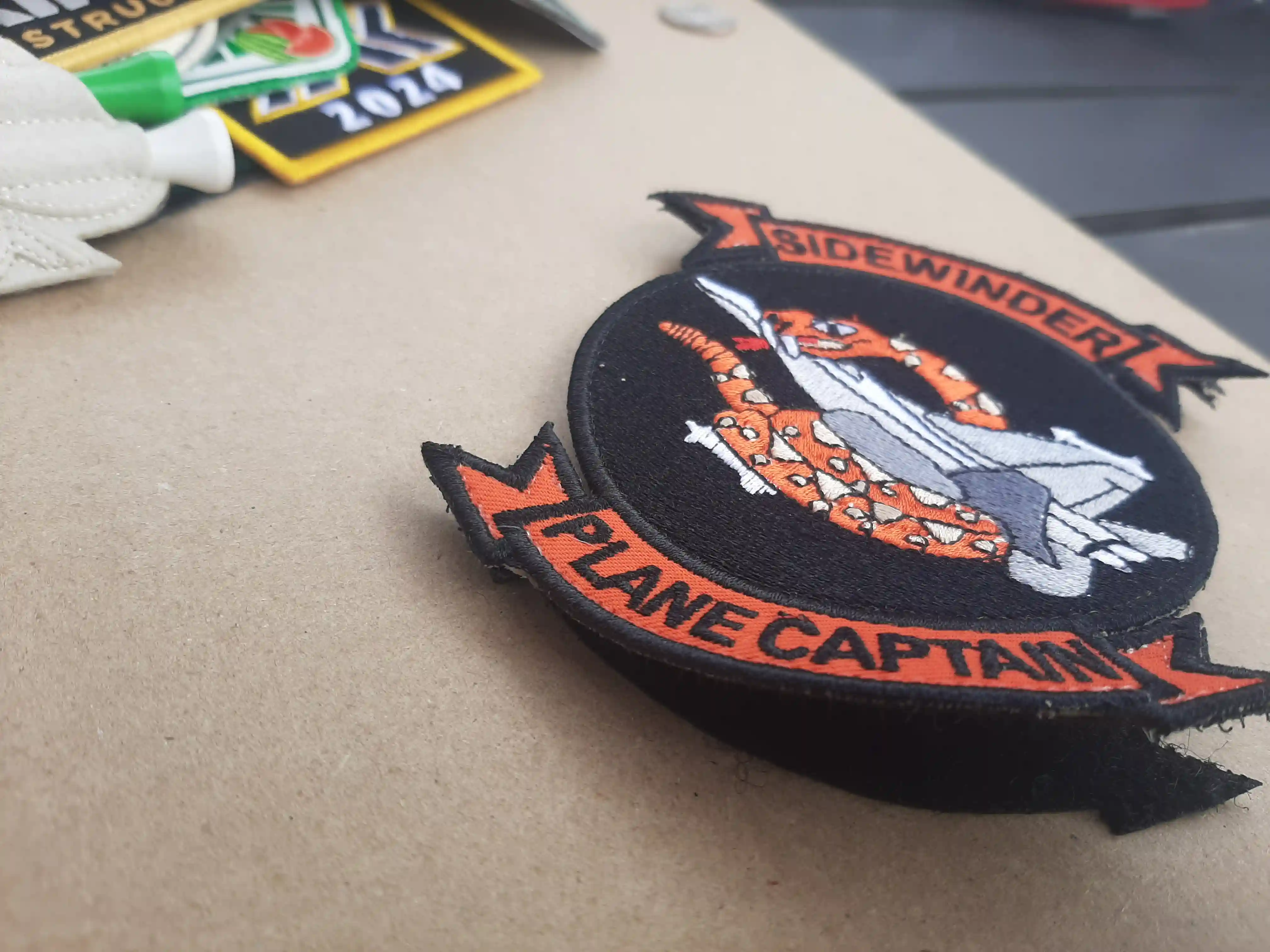 Plane Captain banner portrayed with a Top banner of Side Winder type plane. The central logo is of the sidewinder. The velcro (cut to shape) is shown – Embroidered Patches